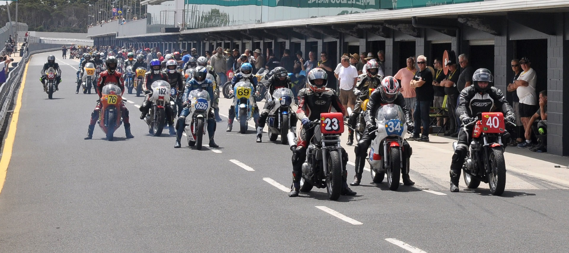 Vintage motorcycles on pit lane at Phillip Island during a past International Island Classic event. Photo courtesy of Phillip Island Grand Prix Circuit.