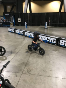 A determined little kid on an electric STACYC 12eDrive on a demo course at the IMS show in Long Beach, California. Photo by John Ulrich. 