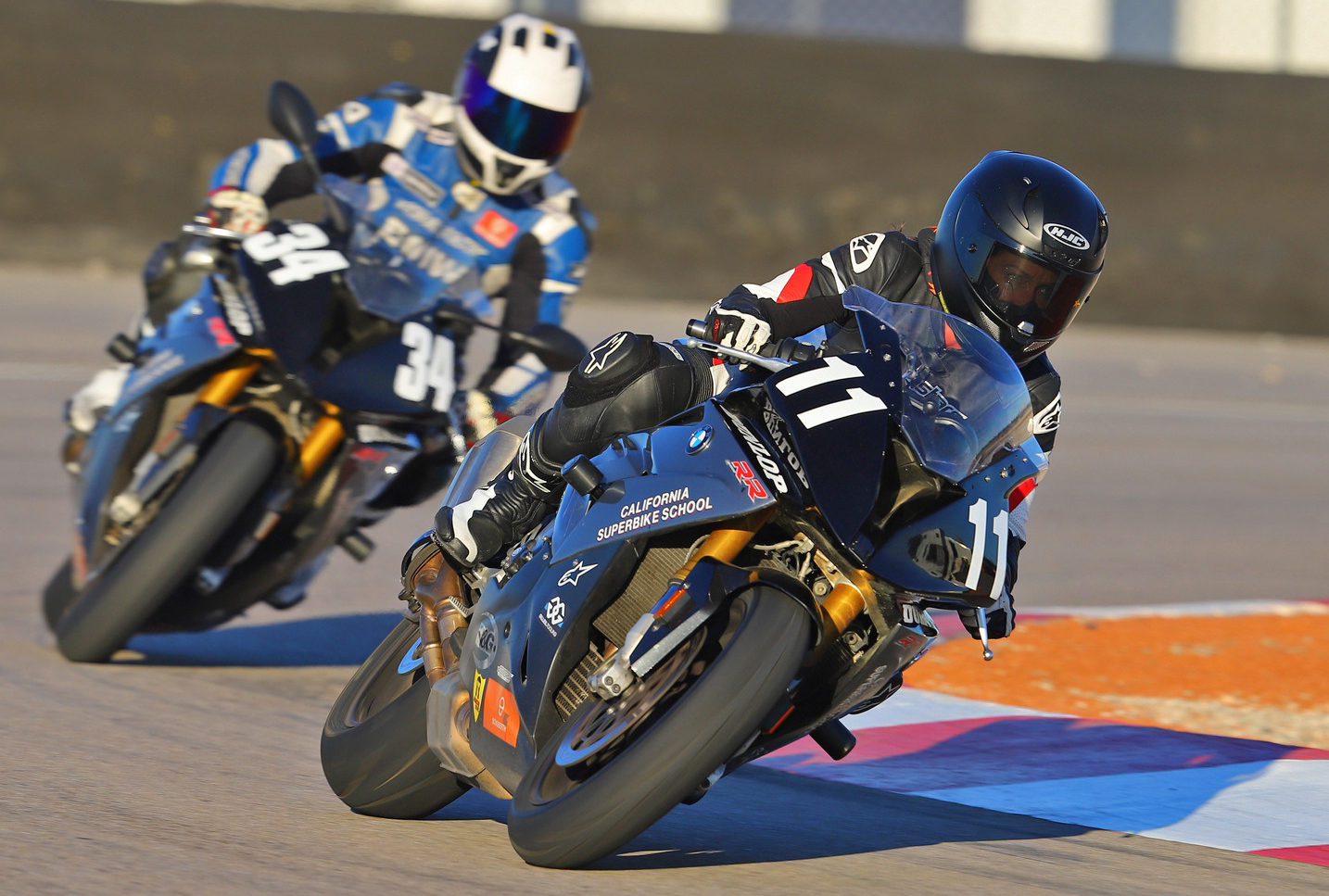 A California Superbike School instructor (34) follows a student (11) on track. Photo by etechphoto.com, courtesy of California Superbike School.