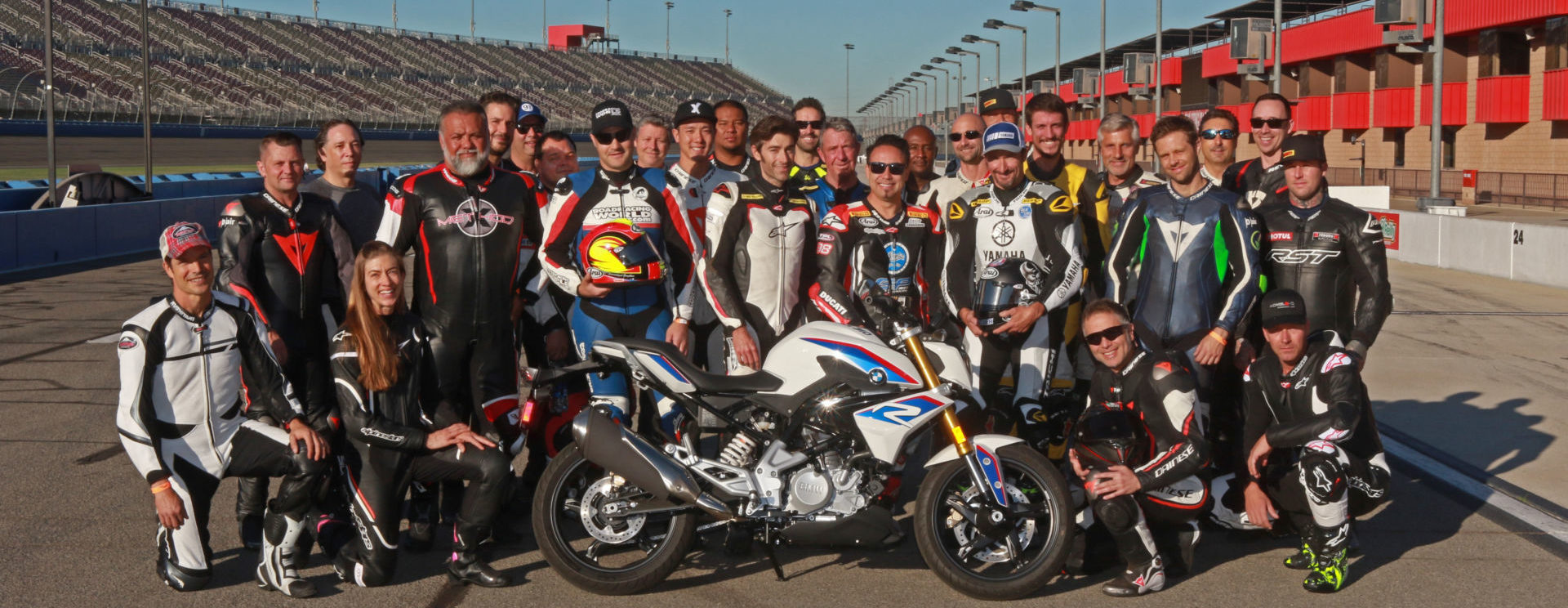 Fastrack Academy V coaches Chris Ulrich, Eric Bostrom, Jake Zemke and Josh Hayes (subbing for Jeremy Toye) and participants with the grand prize, a BMW G 310 R, at Auto Club Speedway. Photo by CaliPhotography.com, courtesy of Fastrack Academy.