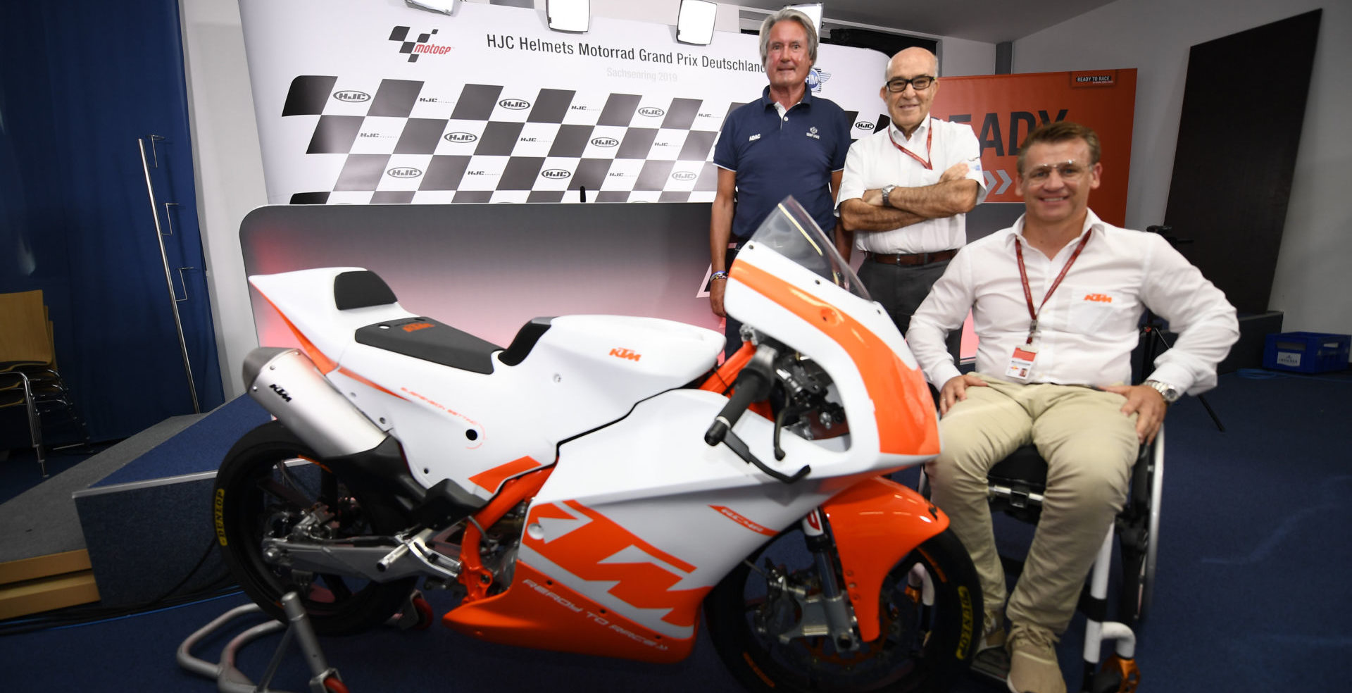 Herman Tomczyk, ADAC Sports President (left); Carmelo Ezpeleta, CEO of Dorna Sports (center); and Pit Beirer, KTM Motorsports Director (right), with a KTM RC4R racebike at the announcement of the Northern Talent Cup. Photo courtesy of Dorna.