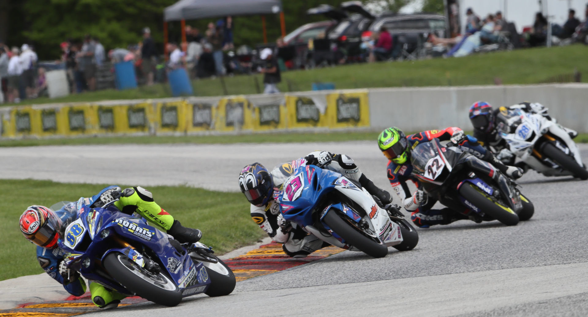 MotoAmerica Supersport competitors Benjamin Smith (88), Lucas Silva (23), Ashton Yates (22), and Cory Ventura (28) racing in front of fans at Road America in 2019. Photo by Brian J. Nelson.