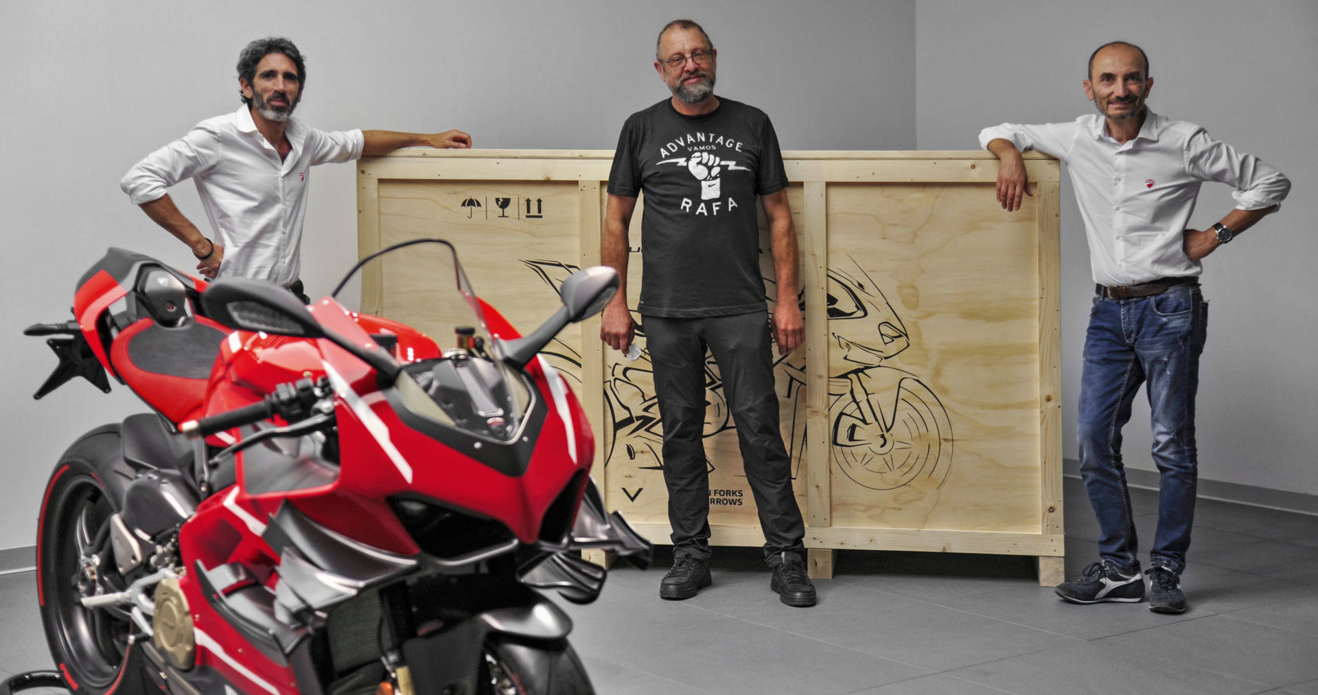 Ducati VP Global Sales and After Sales Francesco Milicia (left) and Ducati CEO Claudio Domenicali (right) deliver Superleggera V4 #001 to Ducatista Filip Van Schil (center) at the Ducati factory in Italy. Photo courtesy Ducati.