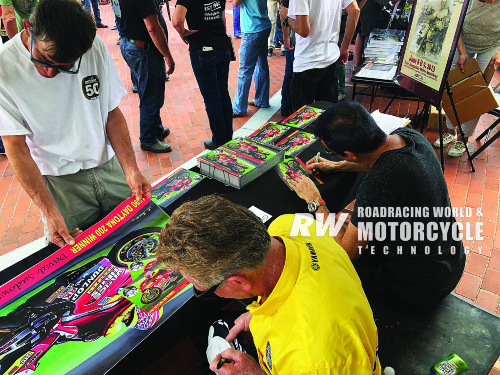 Artist Lee Bivens (right) and previous Daytona 200 race winner David Sadowski (left) signed autographs on small, free hero cards and sold full-size prints of Bivens’ painting of Sadowski to help raise funds for the Daytona 200 Monument Fund. Photo by Bob Coy.