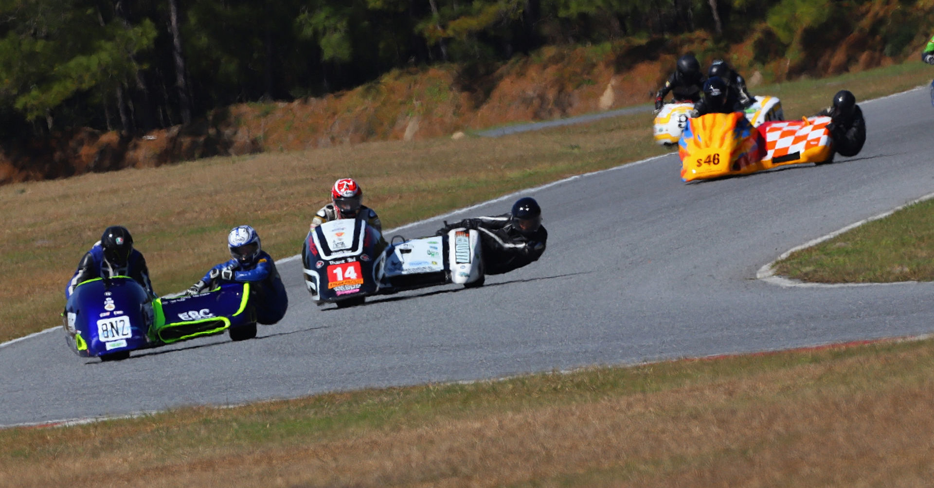 AHRMA sidecar racers Tony Doukas/Lisa Doukas (8NZ), Peter Essaff/Johnny Crown (14), Dale Lavendar/Hunter Longshore (46), and Nick Bailey/Adam Cramer (9) in action in 2020 at Roebling Road Raceway. Photo by etechphoto.com, courtesy AHRMA.