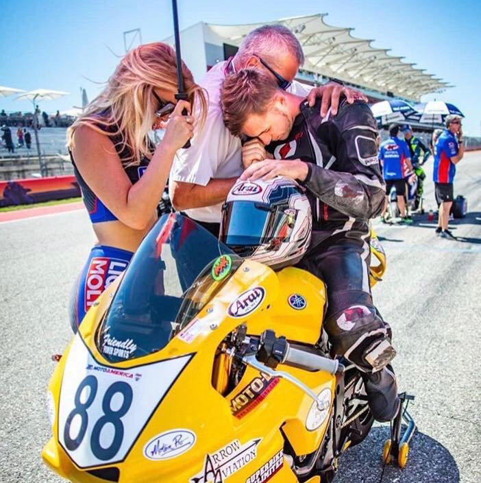 Raymond Rizzo praying with MotoAmerica Superbike racer Max Flinders on the grid before a race at Circuit of The Americas.