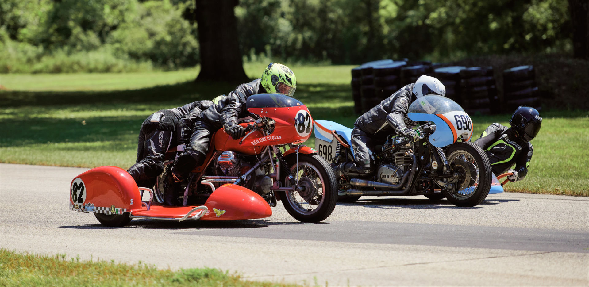 Eric Trosper and passenger Celia Trosper, riding their Loud Valve Racing Moto Guzzi, (X82) and Brad Carlisle and passenger Eddie Neubauer, riding their Sniper Monkey Racing Yamaha, (698) race into Blackhawk Farm Raceway’s Turn Five. Photo by Daniel Peter, courtesy AHRMA.