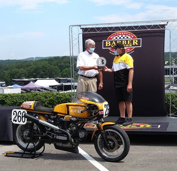 Barber Motorsports Park's George Barber hands Malcome Tunstall the first-place trophy in the 