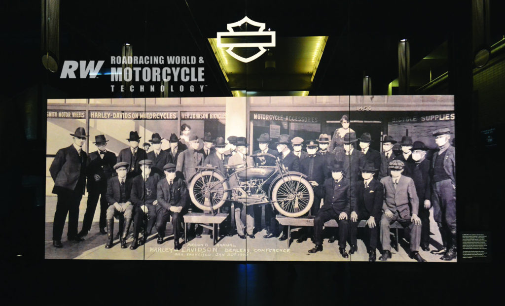 At the Harley-Davidson Museum near Milwaukee, a photo in the reception hall, sourced from a private collector, shows attendees at the 1919 Harley-Davidson dealer show wearing face masks due to the Spanish Flu pandemic.