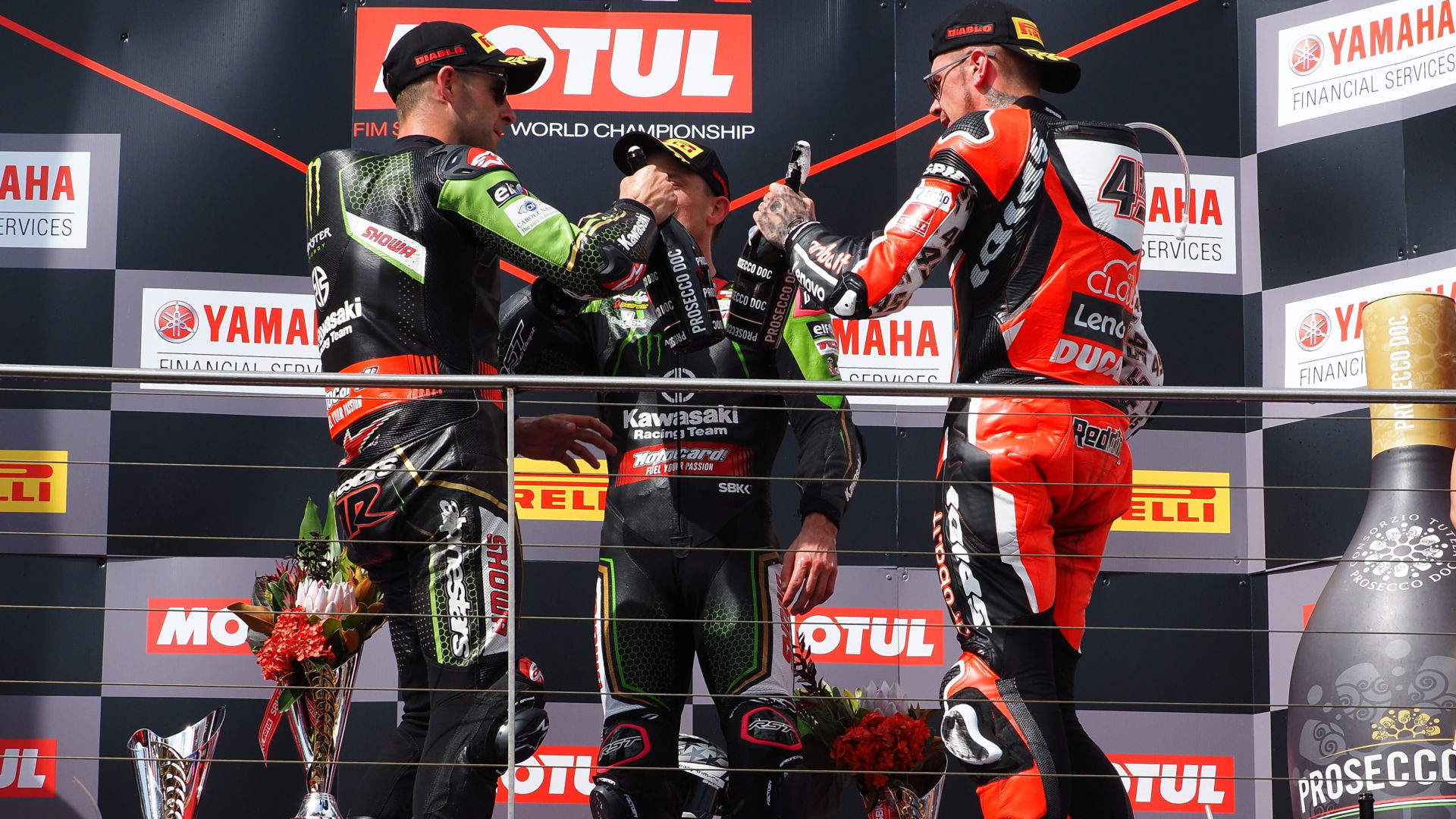 Jonathan Rea (left), Alex Lowes (center) and Scott Redding (right) celebrate with Prosecco champagne on a World Superbike podium. Photo courtesy Dorna.