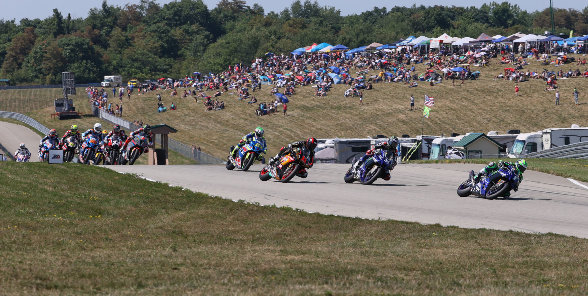 Cameron Beaubier (1) leads Jake Gagne (32), Mathew Scholtz (11), Toni Elias (24) and the rest of the field at the start of MotoAmerica HONOS Superbike Race Two at PittRace. Photo by Brian J. Nelson, courtesy MotoAmerica.