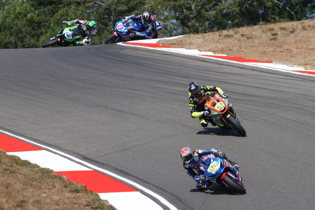 Sean Dylan Kelly (40) leads Brandon Paasch (21)  while Xavier Zayat (24) crashes in front of Lucas Silva (23) at the start of the MotoAmerica Supersport race at Ridge Motorsports Park. Photo by Brian J. Nelson, courtesy MotoAmerica.