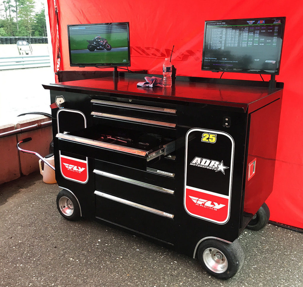 Seen On Pit Lane: Aussie Dave Racing (ADR) has a rolling toolbox with a TV for the live video feed and another TV for the timing and scoring feed. Photo by John Ulrich.