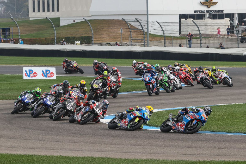 Bobby Fong (50) leads Toni Elias (24), Kyle Wyman (33), Lorenzo Zanetti (87), Jake Gagne (32), Cameron Beaubier (1), and the rest of the MotoAmerica Superbike field at Indianapolis Motor Speedway. Photo by Brian J. Nelson, courtesy MotoAmerica.