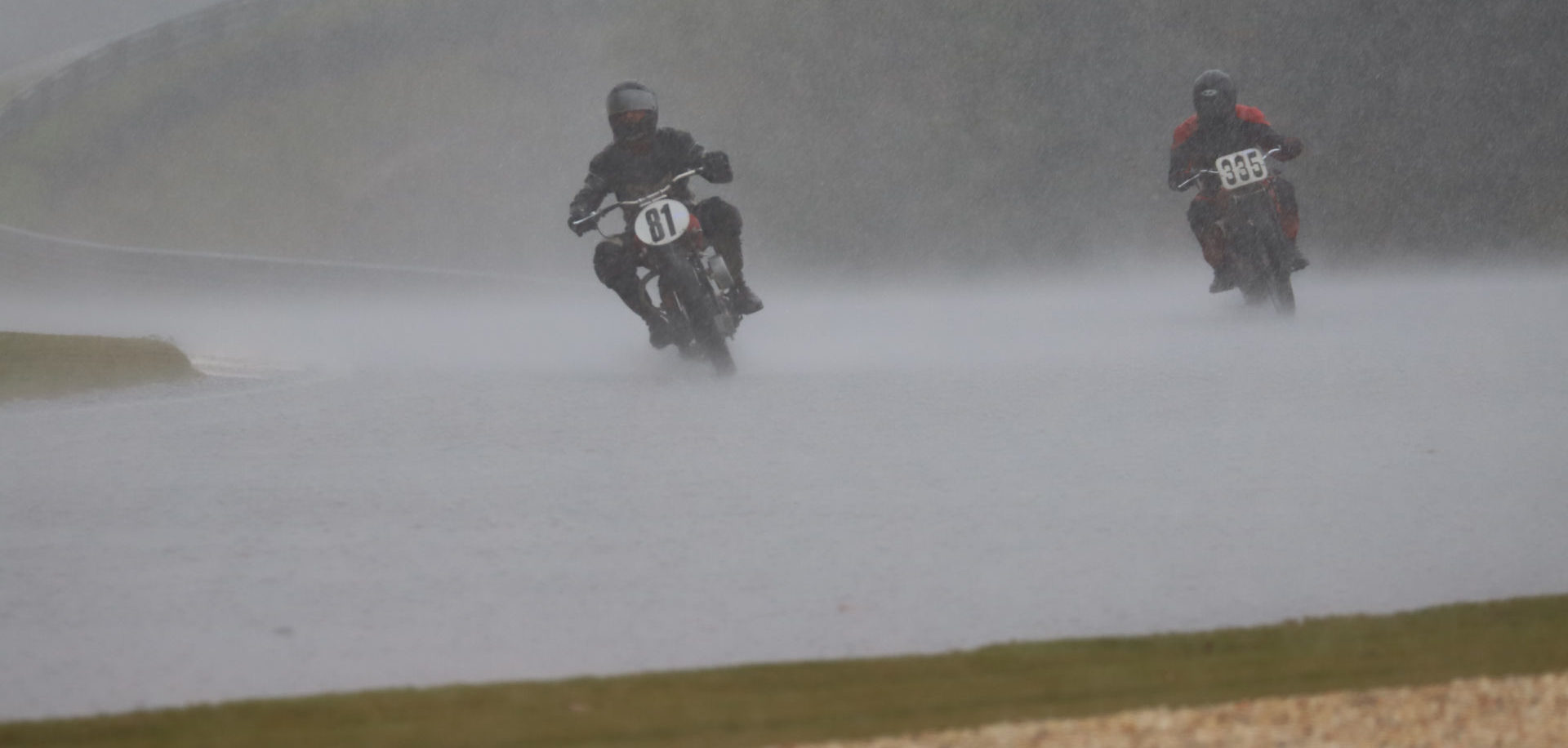 AHRMA Handshift Shootout competitors Ralph Wessell (81) and Tim Droege (335) race in the pouring rain at Barber Motorsports Park. Photo by etechphoto.com, courtesy AHRMA.