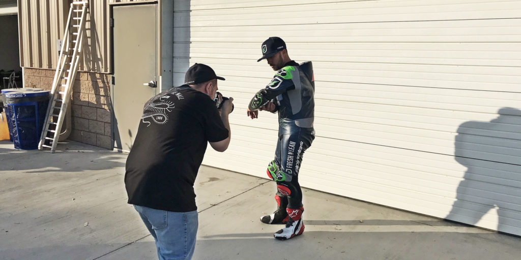 Josh Herrin showing off a worn-out elbow slider on his Fresh n' Lean Alpinestars leathers. Photo by Michael Gougis.