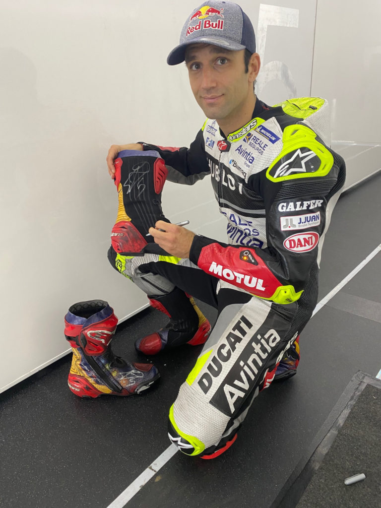 Johann Zarco autographs a set of his boots. Photo courtesy Dorna.