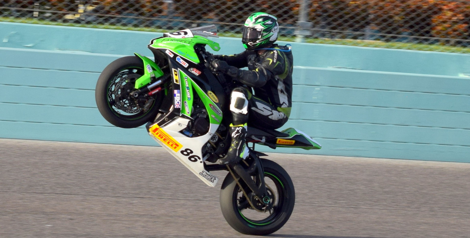 Jason Farrell (86) wheelies the Farrell Performance Kawasaki ZX-10R to the checkered flag in the ASRA Team Challenge at Homestead-Miami Speedway. Photo by Rick Hentz.