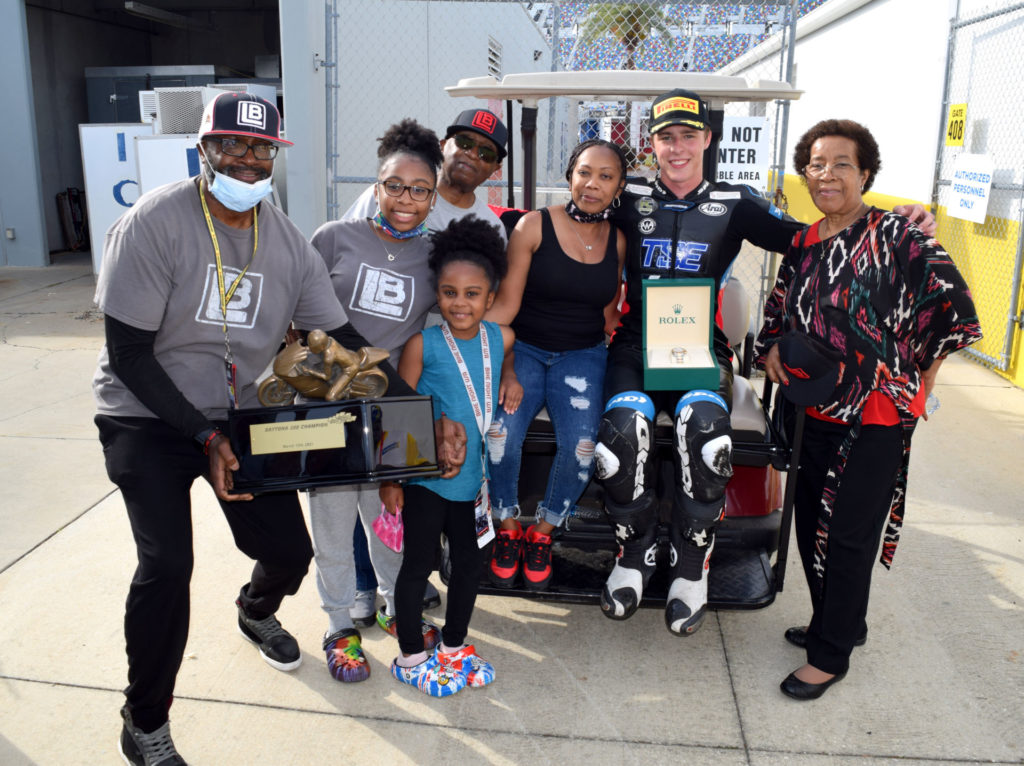 Brandon Paasch with friends and family of Lloyd Bayley. (From left) Gill Lindsay (Bayley’s friend), Alyssia Bayley (Bayley’s daughter), Alana Bayley (Bayley’s daughter), Leonard Bayley (Bayley’s father), Yvett Bayley (Bayley’s widow), Brandon Paasch, and Ethel Bayley Scruggs (Bayley’s mother). Photo by Rick Hentz/Ricks Pics.