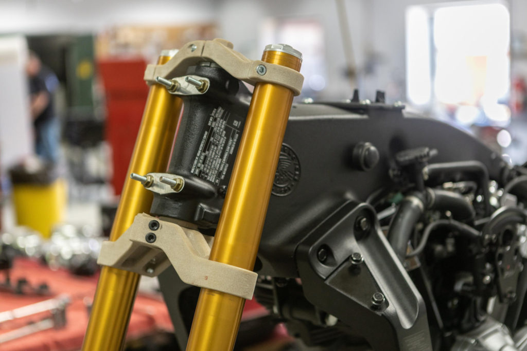 Indian FTR1200 forks and billet triple clamps this photo shows 3D-printed prototype triple clamps) provide a steep steering angle. Photo courtesy of S&S Cycle and MotoAmerica.