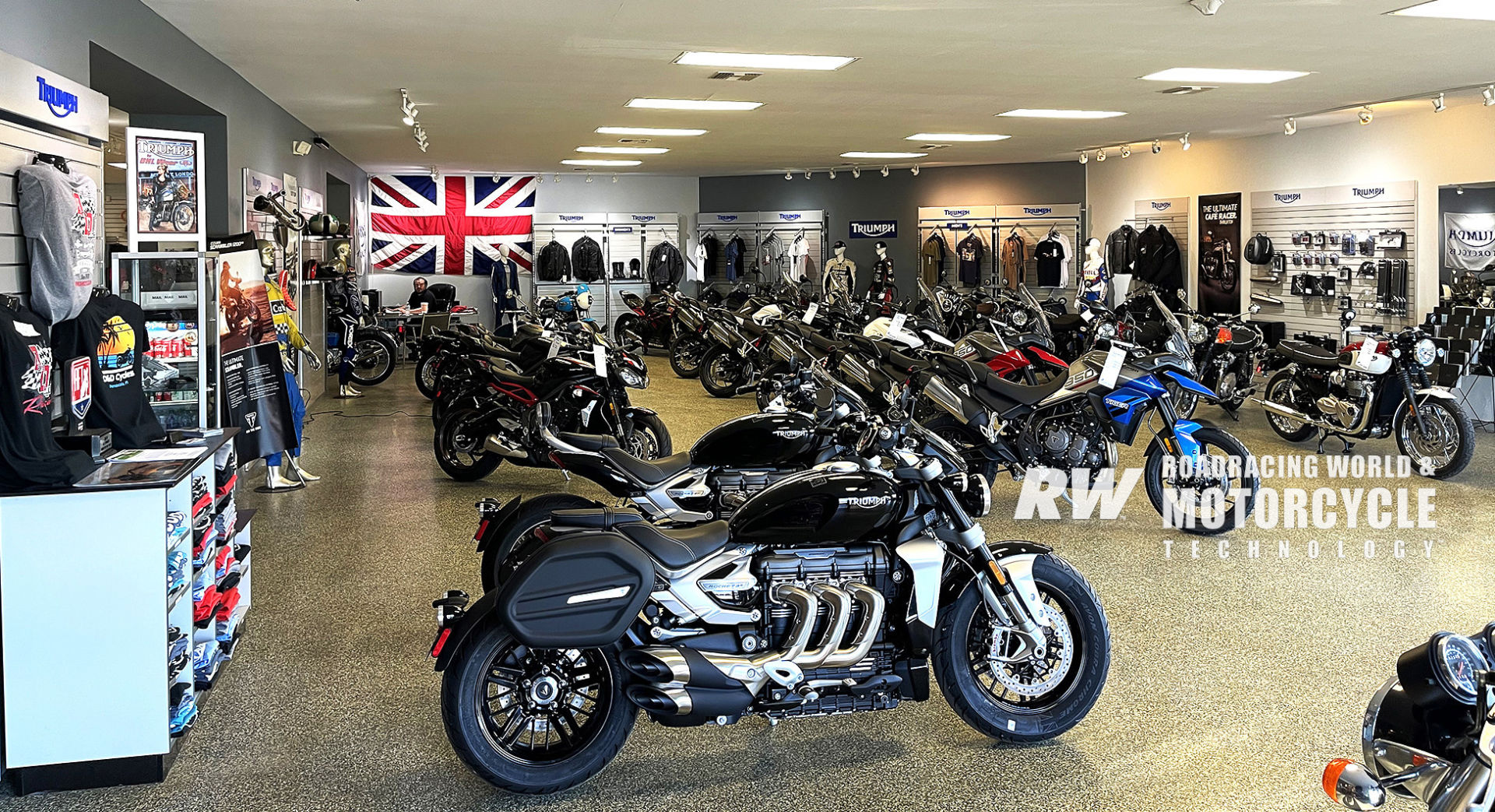 The D&D Cycles showroom in Pensacola, Florida, with Triumph, MV Agusta, and Aprilia models on display, and Rob McLendon at his desk in the background. Photo by Dalton Gauthier.