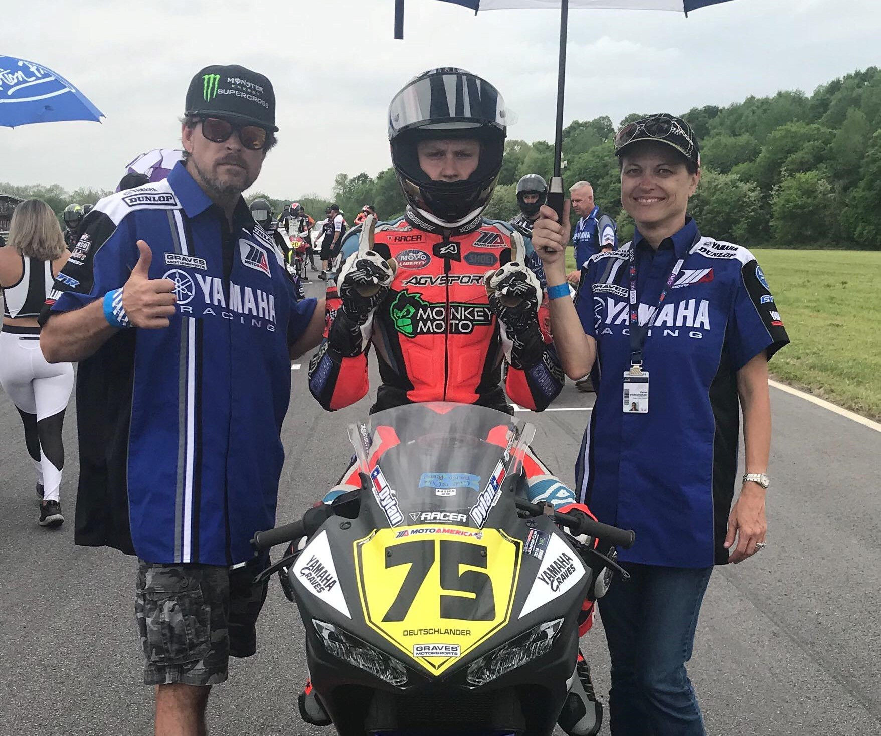 Karen Deutschlander (right) on the grid with son Dylan Deutschlander (center) at a MotoAmerica race. Photo by Brian J. Nelson.