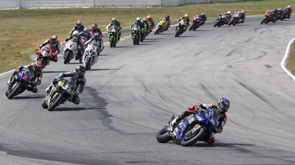 Jake Gagne (32) leads Kyle Wyman (33), Josh Herrin (2), Loris Baz (76), Travis Wyman (10), Hector Barbera (80), Bobby Fong (50) and the rest of the field at the start of Superbike Race Two. Photo by Brian J. Nelson, courtesy MotoAmerica.