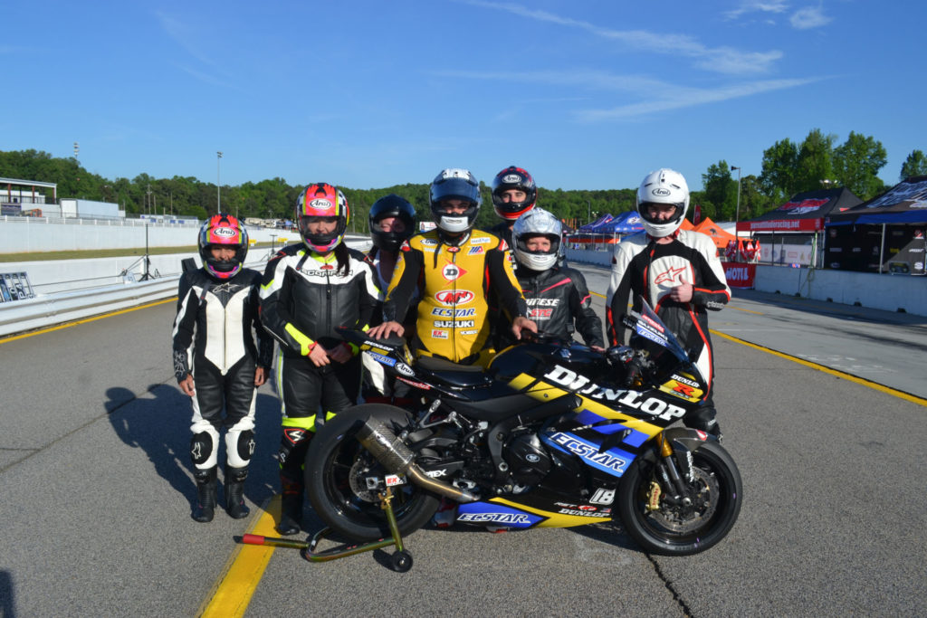 Chris Ulrich (center) poses with a group of passengers after giving rides on the Dunlop ECSTAR Two-Seat Superbike. ECSTAR is co-title sponsor of the program in 2021. Photo courtesy Team Hammer.