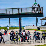 Starter Ed Bargy waves the green flag to start a combined Classic Sixties, Classic Sixties 650, Sportsman 500, Formula 250, and 250 Grand Prix race during the AHRMA Classic MotoFest in the Heartland at Heartland Motorsports Park, in Topeka, Kansas. Photo by Chuck Hanna, courtesy AHRMA.