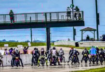 Starter Ed Bargy waves the green flag to start a combined Classic Sixties, Classic Sixties 650, Sportsman 500, Formula 250, and 250 Grand Prix race during the AHRMA Classic MotoFest in the Heartland at Heartland Motorsports Park, in Topeka, Kansas. Photo by Chuck Hanna, courtesy AHRMA.