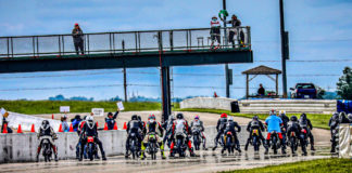 Starter Ed Bargy waves the green flag to start a combined Classic Sixties, Classic Sixties 650, Sportsman 500, Formula 250, and 250 Grand Prix race during the AHRMA Classic MotoFest in the Heartland at Heartland Motorsports Park, in Topeka, Kansas. Photo by Chuck Hanna, courtesy AHRMA.