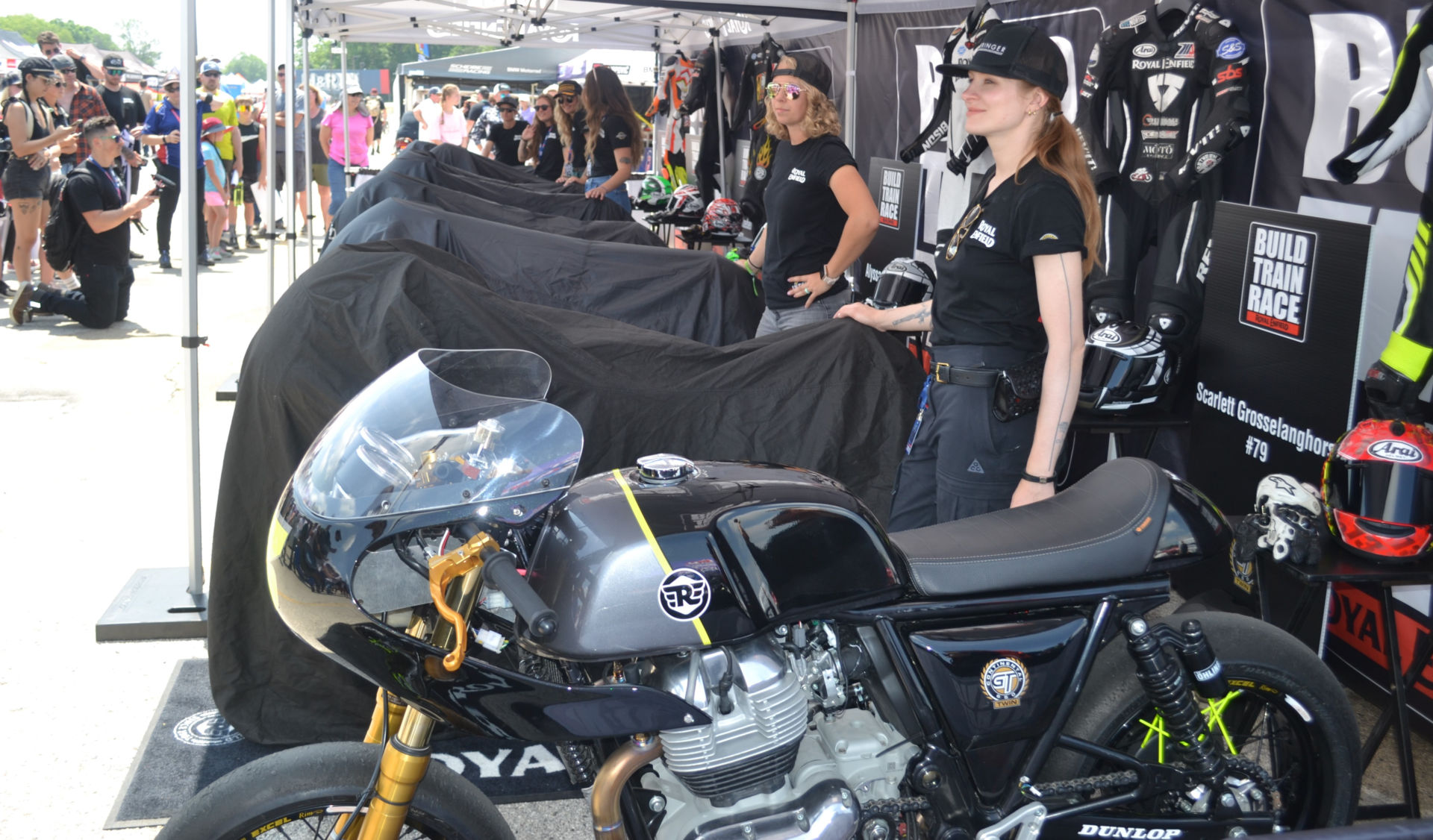 Royal Enfield Build Train Race (BTR) road race participants Scarlett Grosselangehorst (right) and Trisha Dahl (left) with their Royal Enfield Continental GT 650 racebike builds under covers. BTR program mentor Melissa Paris’ Royal Enfield racebike is in the foreground. Photo by David Swarts.