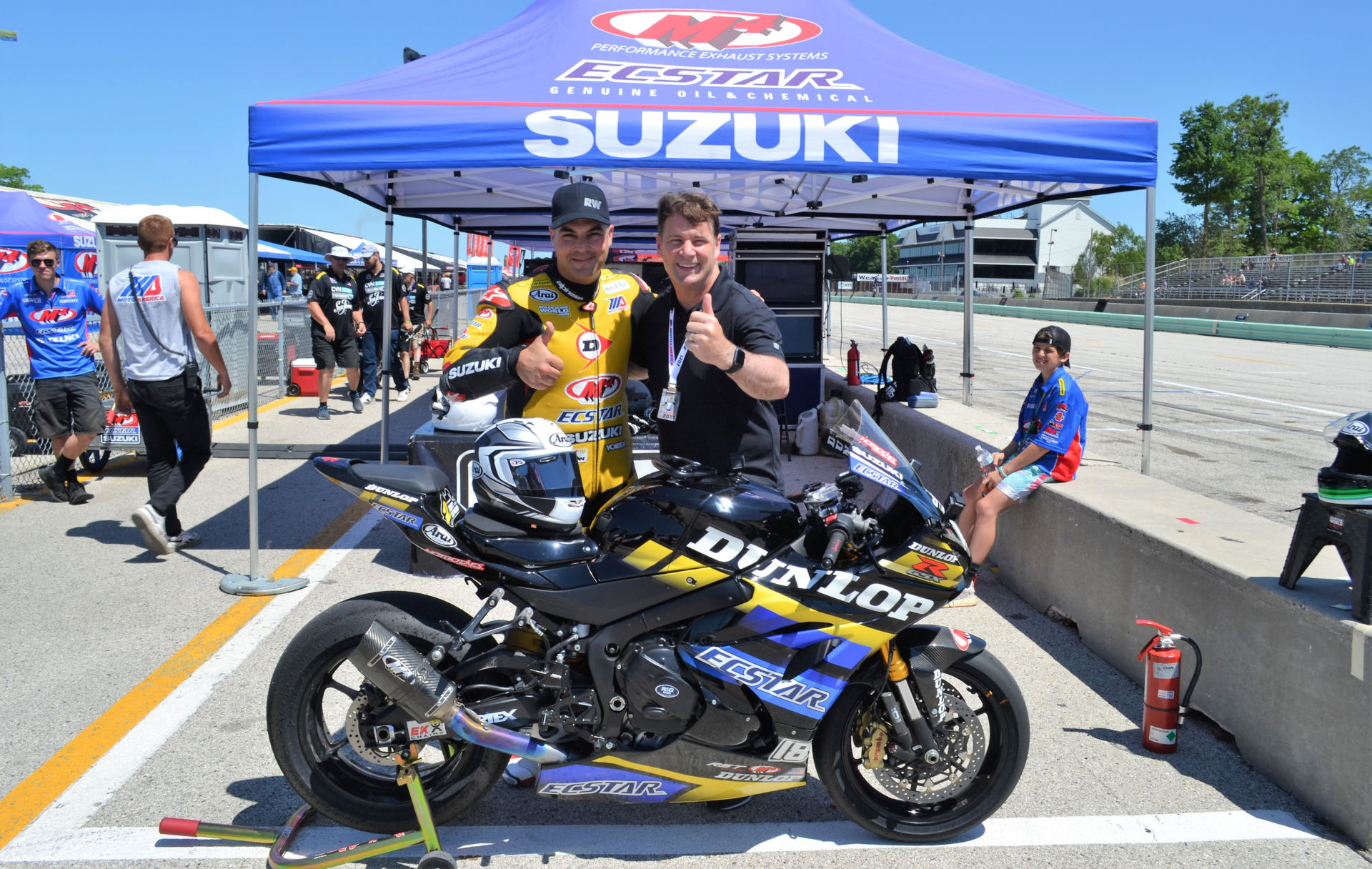 Ford President and CEO Jim Farley (right) with former Superbike racer Chris Ulrich (left) after they rode together on the Dunlop ECSTAR Suzuki GSX-R1000R two-seat Superbike June 13 during the MotoAmerica event at Road America. Photo by David Swarts.