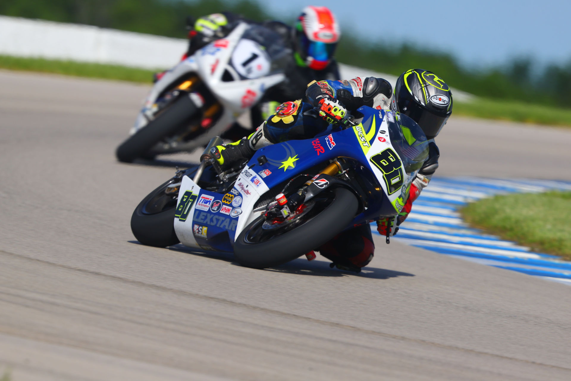 AHRMA Sound of Singles competitor Ralph Staropoli (80), riding a Honda NSF250R, leads AHRMA Sound of Thunder competitor Chris Haesemeyer (1), and his Triumph Daytona 675, at Heartland Motorsports Park. Photo by etechphoto, courtesy AHRMA.