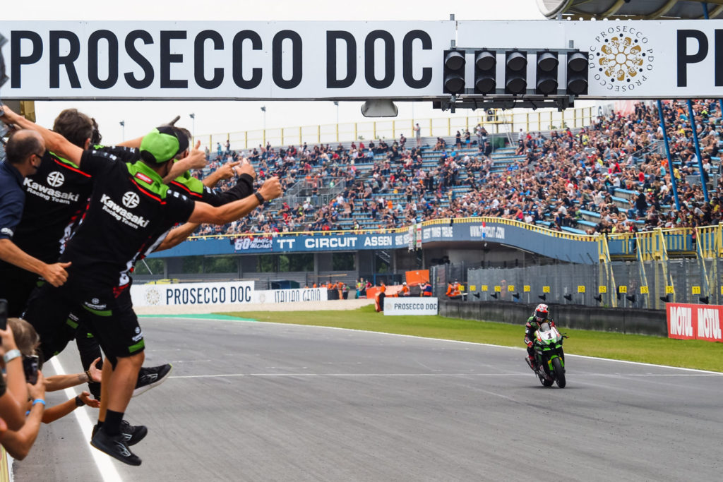 Jonathan Rea's (1) team greets him with cheers as he takes the checkered flag at Assen. Photo courtesy Dorna.