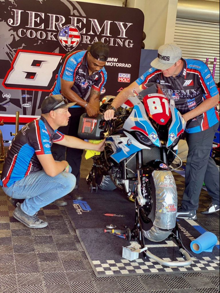 Jeremy Cook Racing VETM volunteers Patrick Corey (left), Alex Panetta (center) and team mechanic Dakari Harris (right) work to get the team's BMW S 1000 RR ready for the Stock 1000 race at Laguna Seca. Photo courtesy of Jeremy Cook Racing.