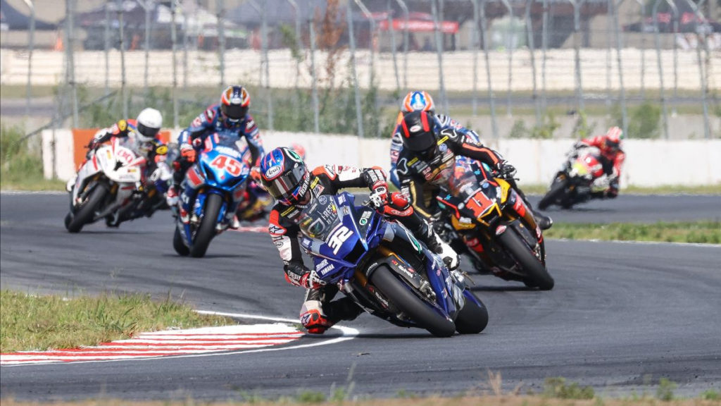 Jake Gagne (32) leads Mathew Scholtz (11), Bobby Fong (behind Scholtz), Cameron Petersen (45), Hector Barbera (80), and the rest of the field early in restarted MotoAmerica Superbike Race One at Brainerd. Photo by Brian J. Nelson.