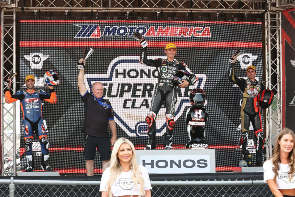 Superbike Race One winner Jake Gagne and his crew chief Jon Cornwall (center) flanked by runner-up Bobby Fong (left) and third-place finisher Mathew Scholtz (right) on the podium at Brainerd. Photo by Brian J. Nelson.