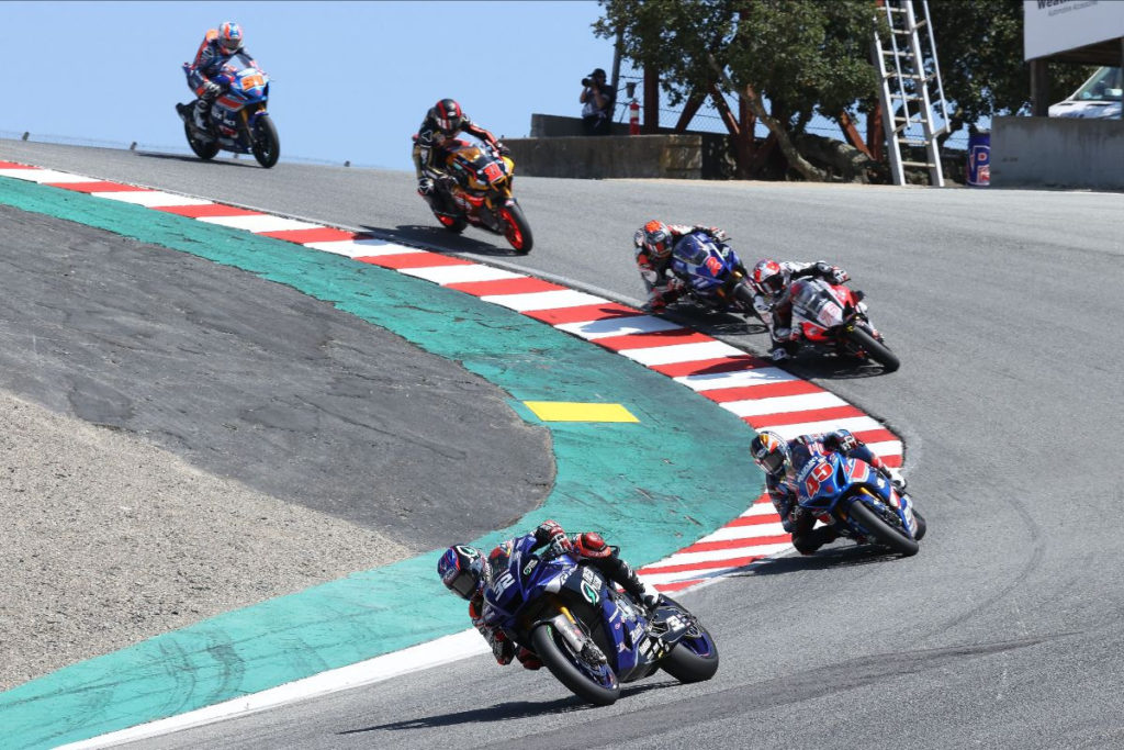 Jake Gagne (32) leads Cameron Petersen (45), Loris Baz (76), Josh Herrin (2), Mathew Scholtz (11), and Bobby Fong (50) on the first lap of Superbike Race One at WeatherTech Raceway Laguna Seca. Photo by Brian J. Nelson.