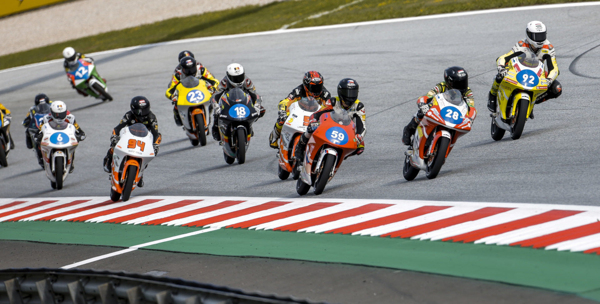 Kevin Farkas (28) leads Jakub Gurecky (59), Hungarian-American Rossi Moor (92), and the rest of the Northern Talent Cup field at the start of Race Two at Red Bull Ring. FIM and Dorna officials are raising the minimum age for racers competing on Grand Prix tracks. Photo courtesy Dorna.