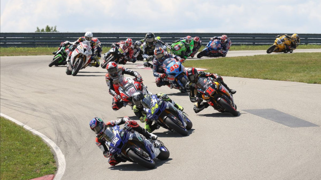 The start of MotoAmerica HONOS Superbike Race One with Jake Gagne (32) leading Toni Elias (24), Mathew Scholtz (11), Loris Baz (76), Cameron Petersen (45), and the rest of the field through Turn Three. Photo by Brian J. Nelson.