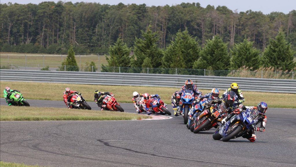 Jake Gagne (32) leads Mathew Scholtz (11), Bobby Fong (behind Scholtz), Cameron Petersen (45) and the rest of the field during a Superbike race Sunday at NJMP. Photo by Brian J. Nelson, courtesy MotoAmerica.