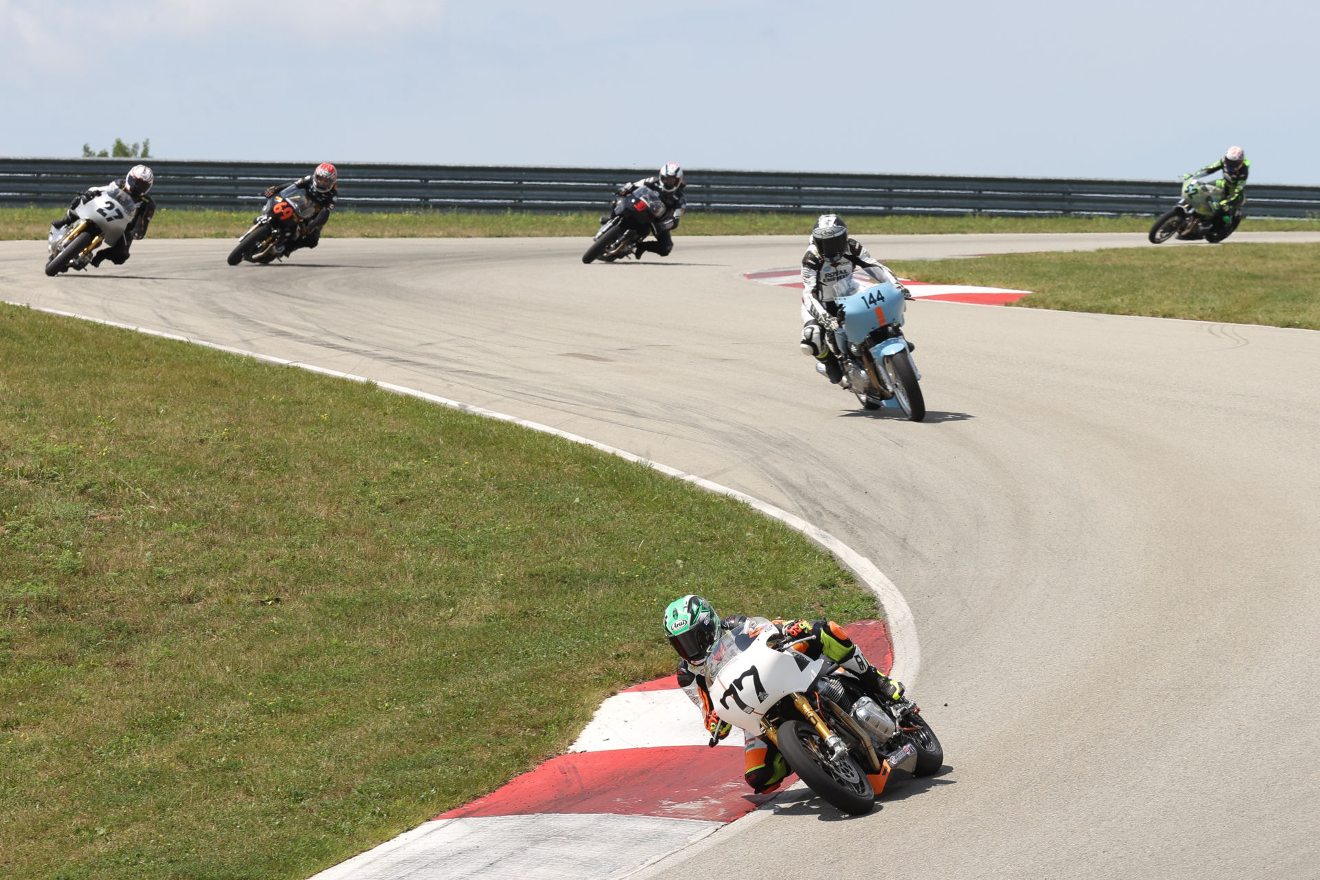 CJ Lukacs (77) leads Trisha Dahl (44) and the rest of the Royal Enfield Build. Train. Race. field at PittRace. Photo by Brian J. Nelson.