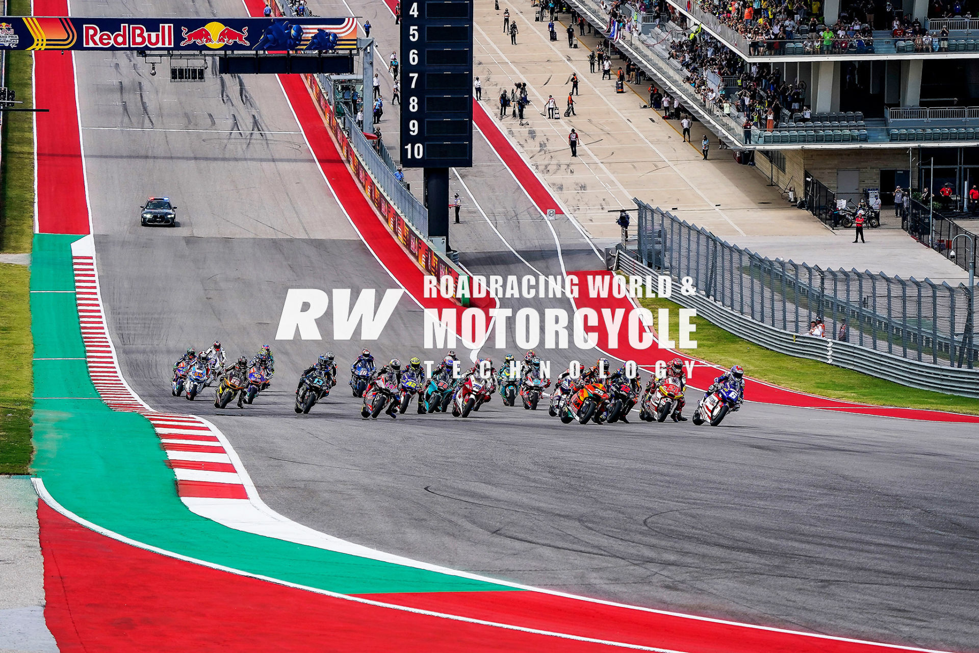 American Cam Beaubier (6) leads a field of Triumph 765 Triple-powered Moto2 racebikes into Turn 1 at Circuit Of The Americas (COTA) in 2021. Like most of the field, Beaubier’s racebike has a Kalex chassis carrying its spec three-cylinder engine. Photo by DPPI Media.