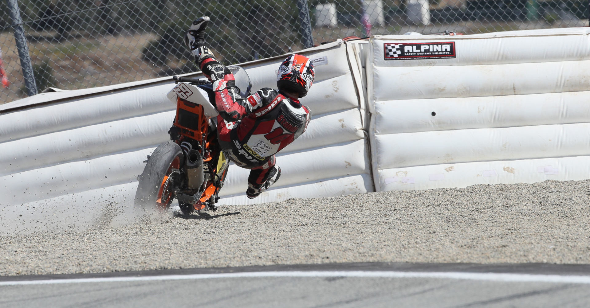 A MotoAmerica Junior Cup racer out of control and heading toward Alpina-brand inflatable safety barriers. Photo by Brian J. Nelson.