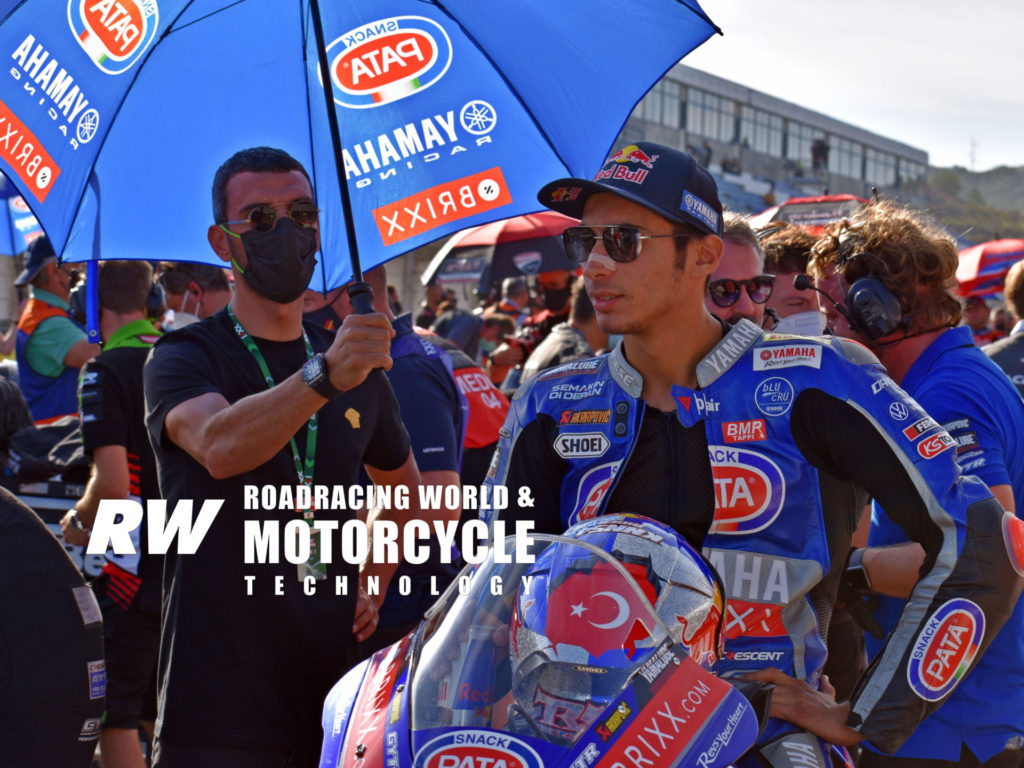 Toprak Razgatlioglu learned and continues to hone his race craft, in part, by banging Supermoto bars with five-time Supersport World Champion Kenan Sofuoglu on Sofuoglu’s home 0.625-mile circuit. Here, Sofuoglu holds Razgatlioglu’s umbrella on the grid at Jerez. Photo by Michael Gougis, copyright 2021.