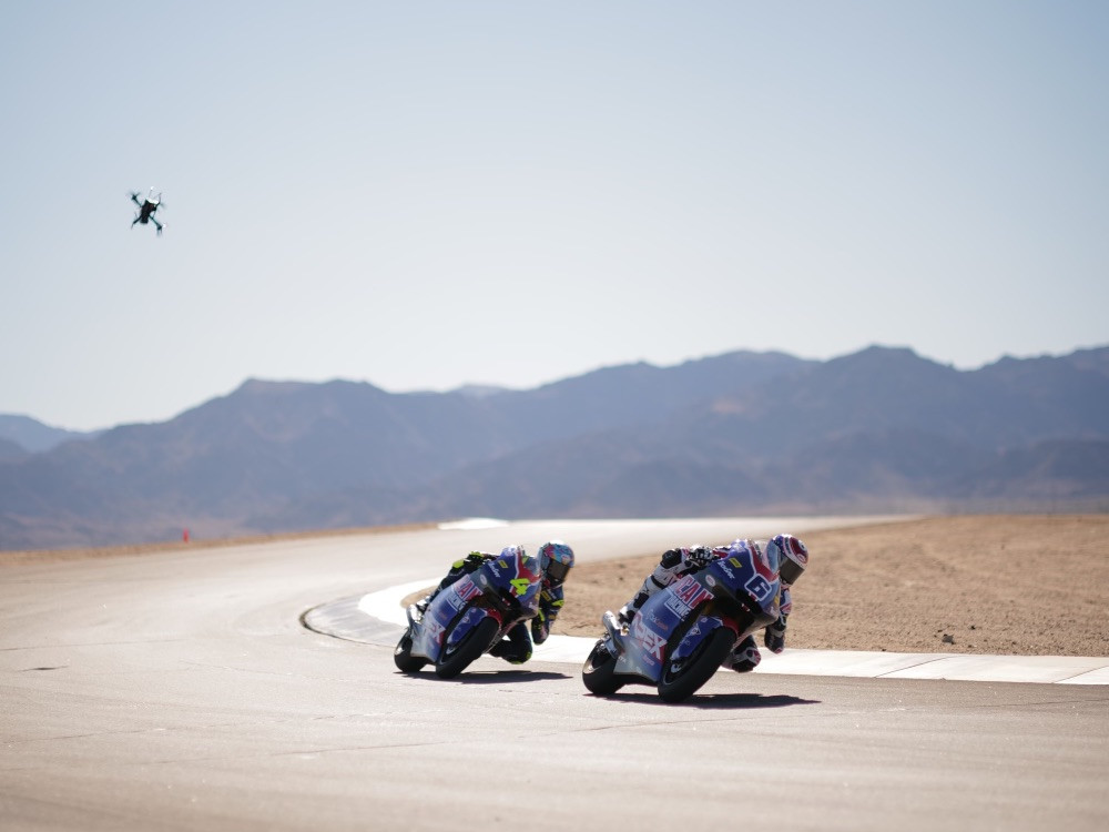 Cameron Beaubier (6) and Sean Dylan Kelly (4) riding their Kalex Moto2 racebikes at Chuckwalla Valley Raceway while being chased by a drone (upper left). Photo courtesy American Racing Team.