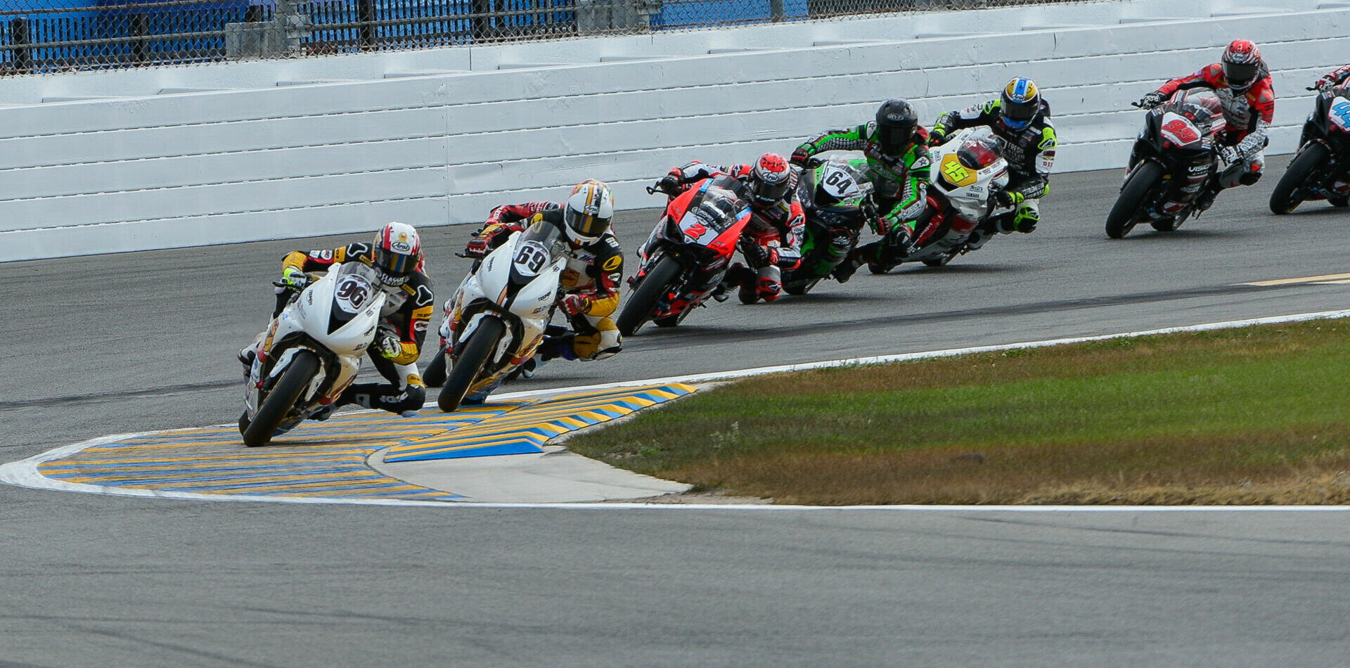 Brandon Paasch (96) leads teammate Danny Eslick (69), Richie Escalante (behind Eslick), Josh Herrin (2), Max Angles (64), Cameron Petersen (450, Geoff May (99), and Sam Lochoff (44) early in the 80th Daytona 200. Photo courtesy Triumph.