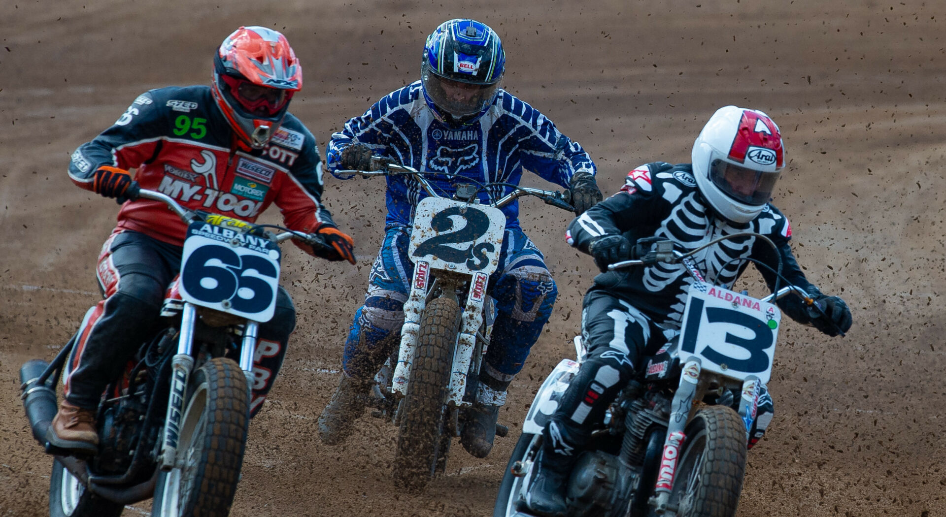 AHRMA flat track racers David Aldana (13), Scott Kay (66), and Charlie Williams (2s) in action. Photo by Dave Sundin, courtesy AHRMA.