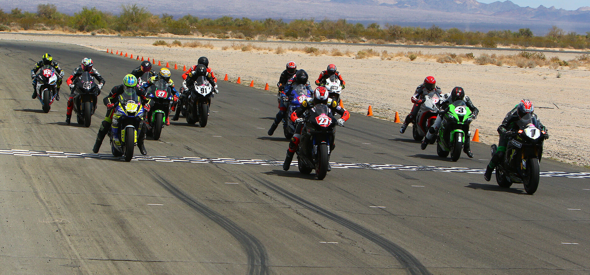 Michael Gilbert (1) leads Toby Khamsouk (27), Rocco Landers (97), Anthony Norton (3), Dallas Sherman Jr, (301), William Russell (46), Sahar Zvik (161), Victor Park (91), Michael Bishop (693), and the rest of the field at the start of the Open Shootout race at Chuckwalla Valley Raceway. Photo by Cali Photography, courtesy CVMA.